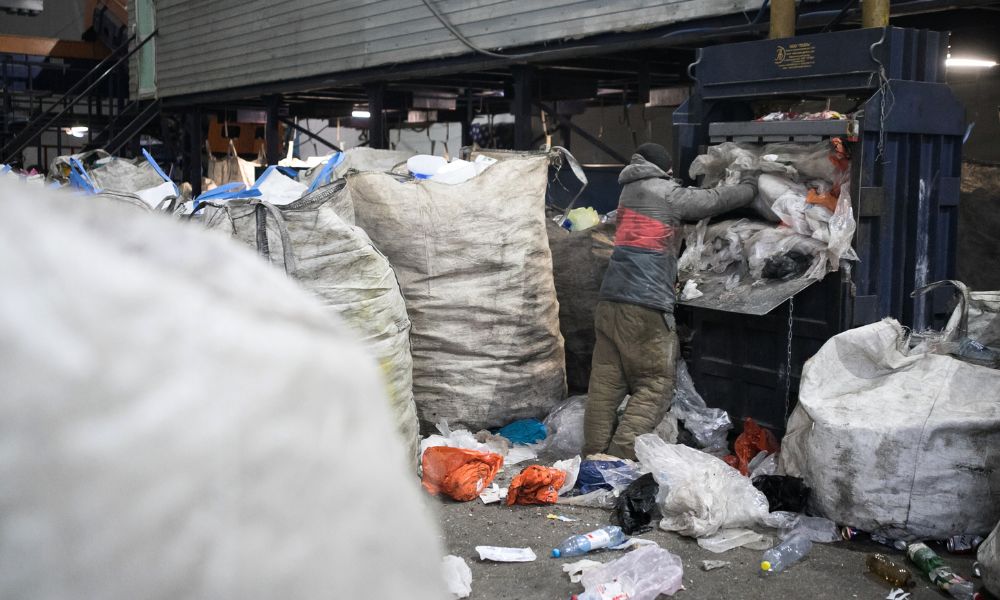 Person loading items into a waste compactor